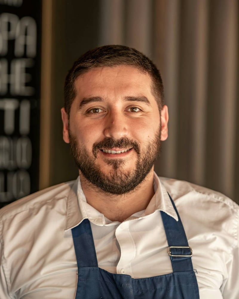A restaurateur in a blue apron