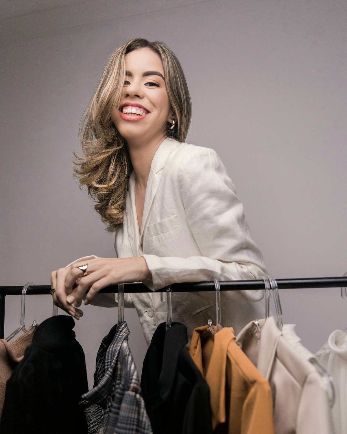 A boutique owner holding a clothes hanger in her shop