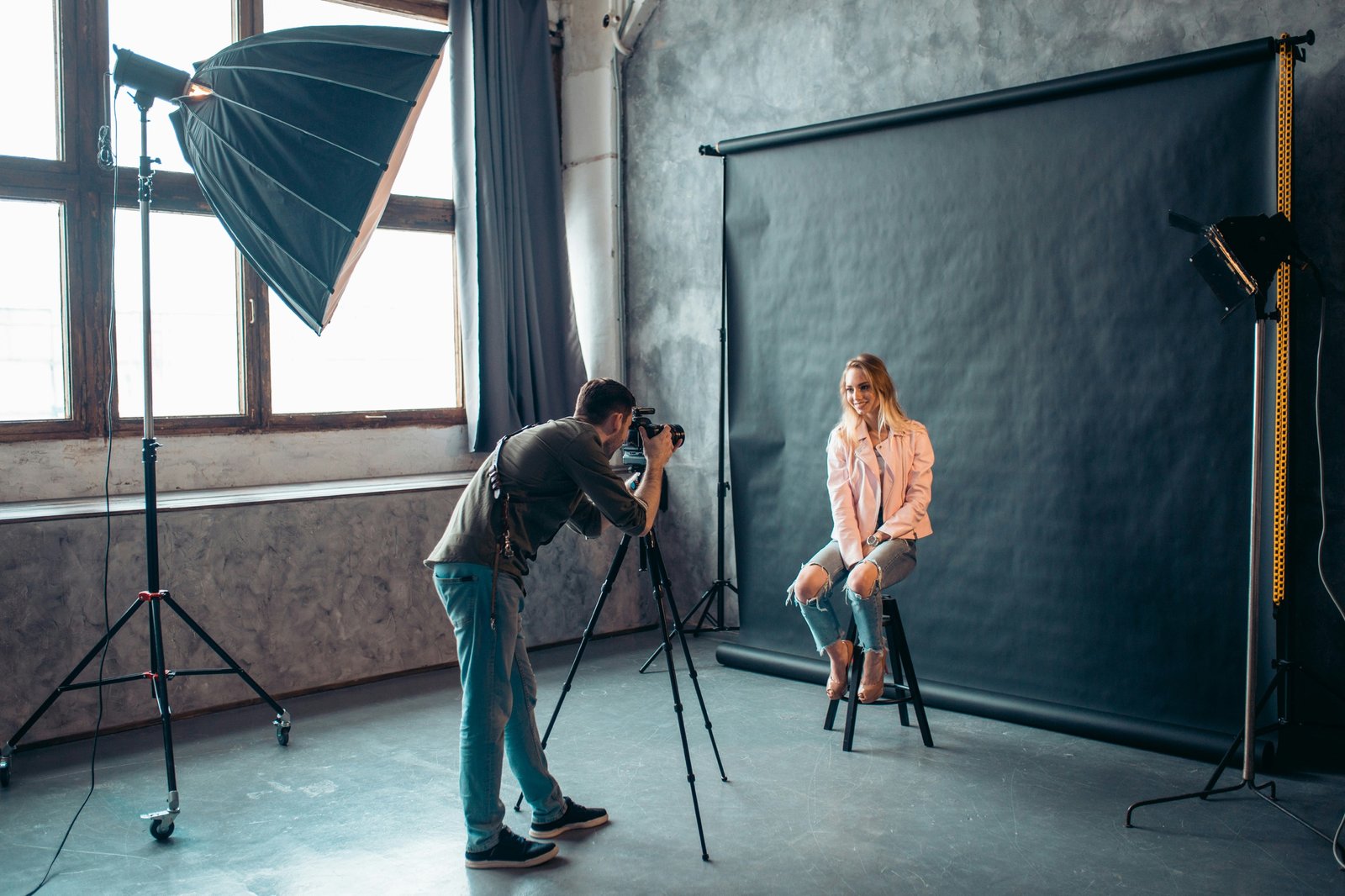 Photographer at work with a model on a grey backdrop