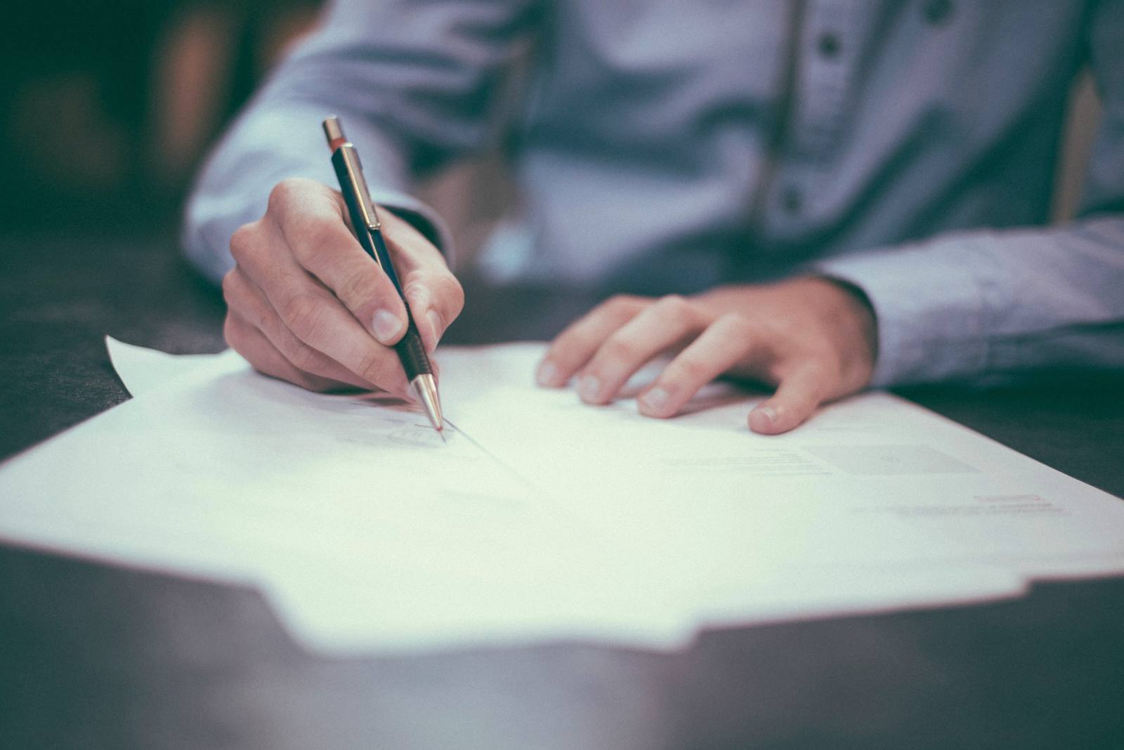 A client signing a printed return at a desk