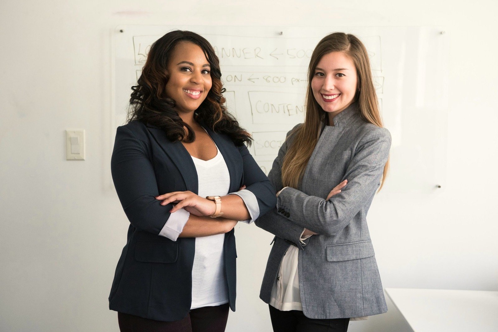 Two colleagues standing together in a bright office