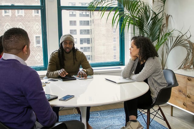 Three colleagues at a round table in a bright office