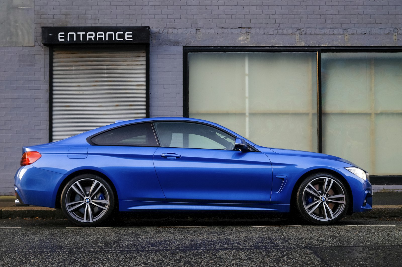 Blue BMW coupe parked on a city street