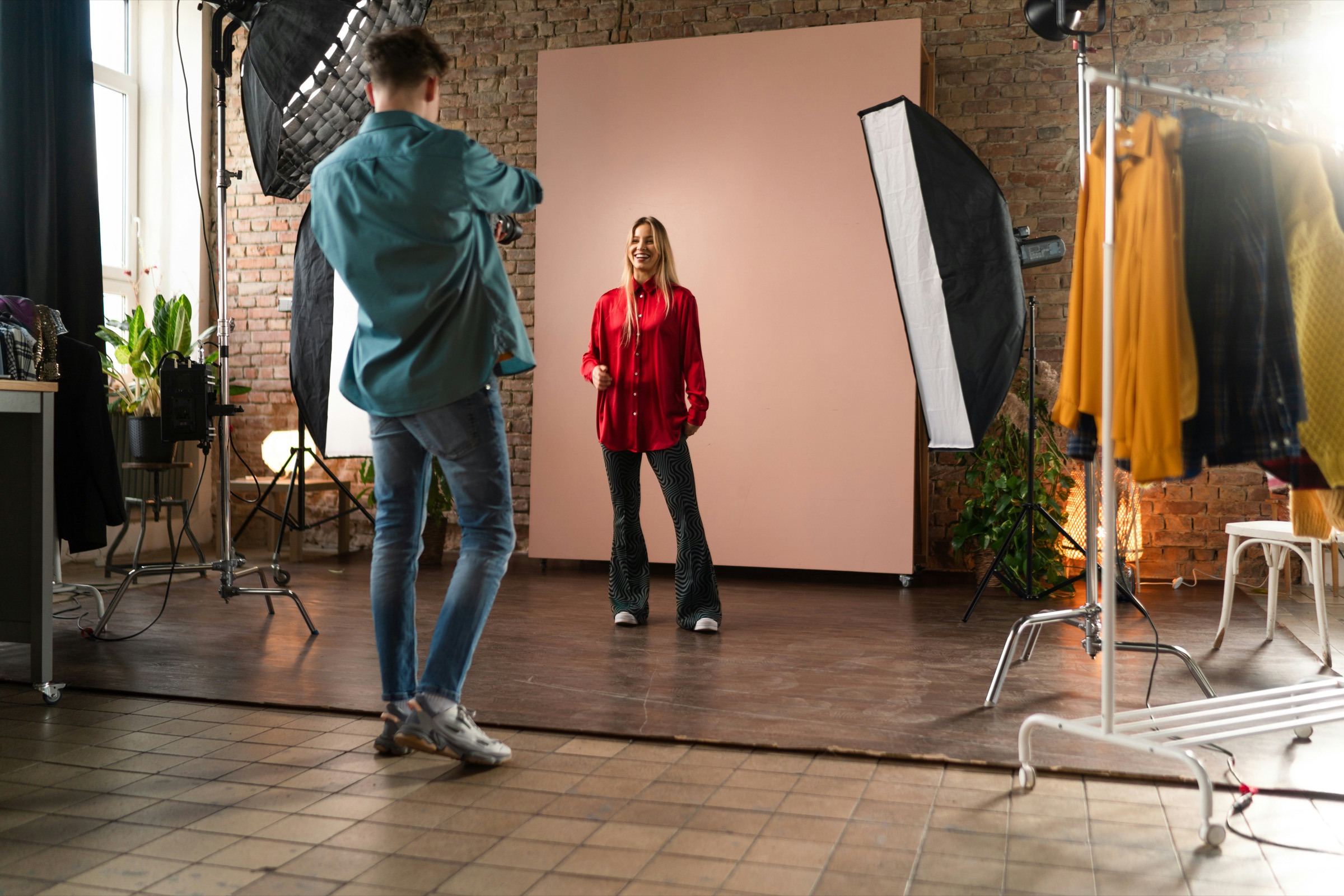 A sitter in a red shirt against a pink paper backdrop
