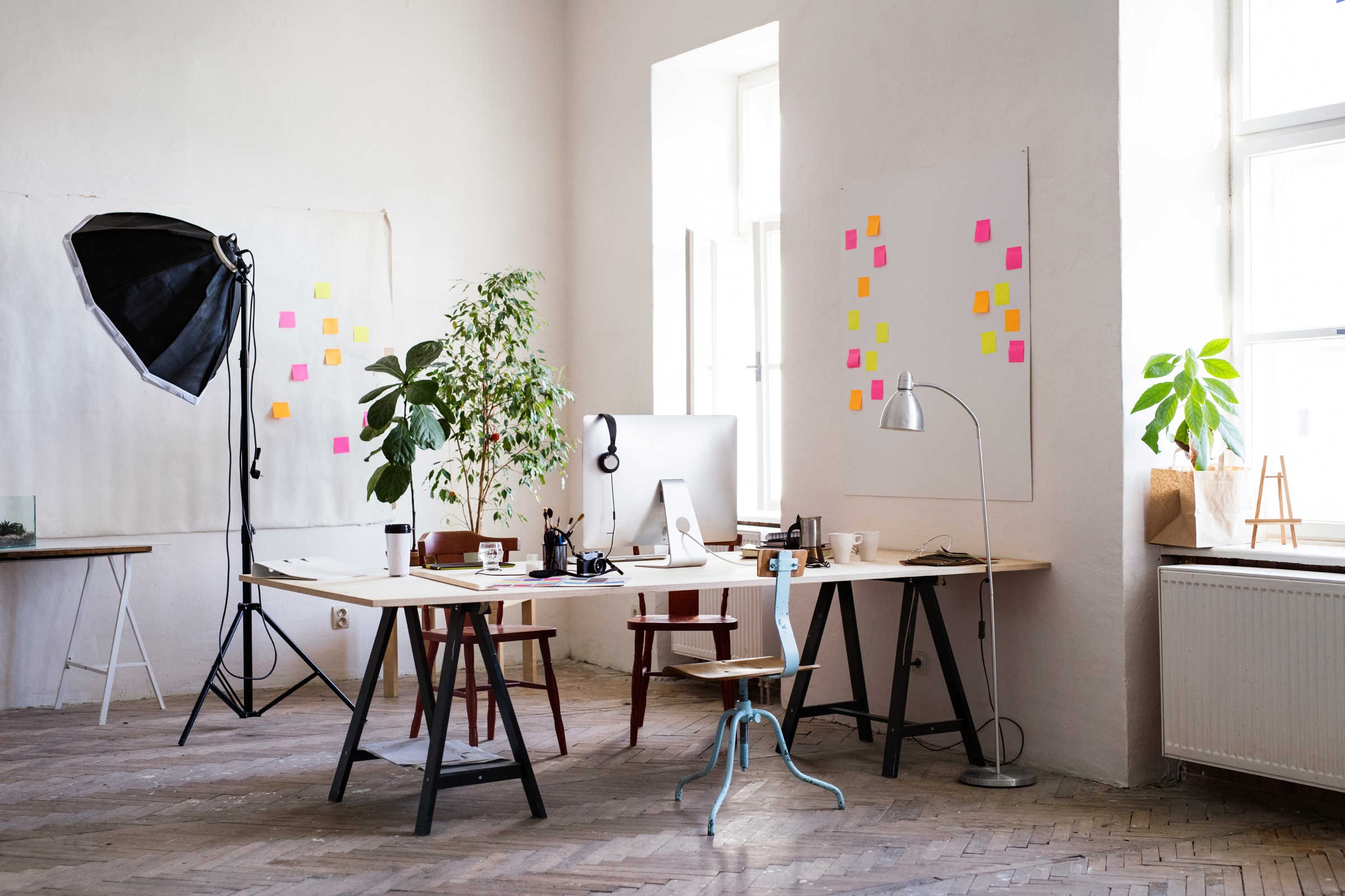 A studio workspace with a light stand and a desk